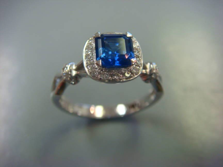 Square blue sapphire engagement ring with a diamond halo and pavé band