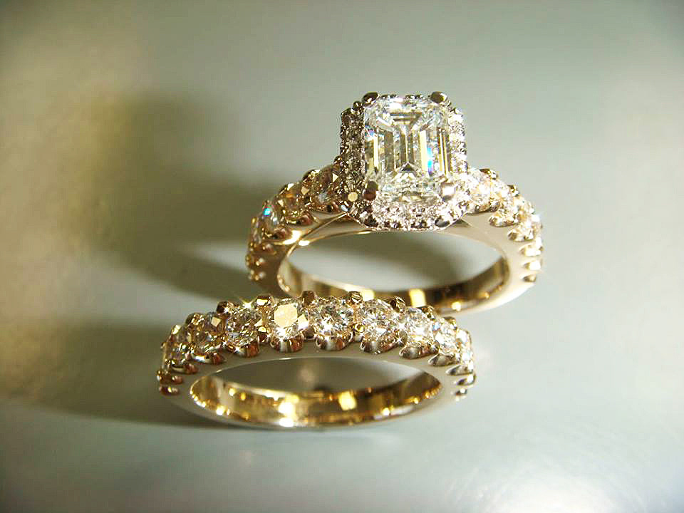 Emerald-cut diamond halo engagement ring with a matching yellow gold wedding band