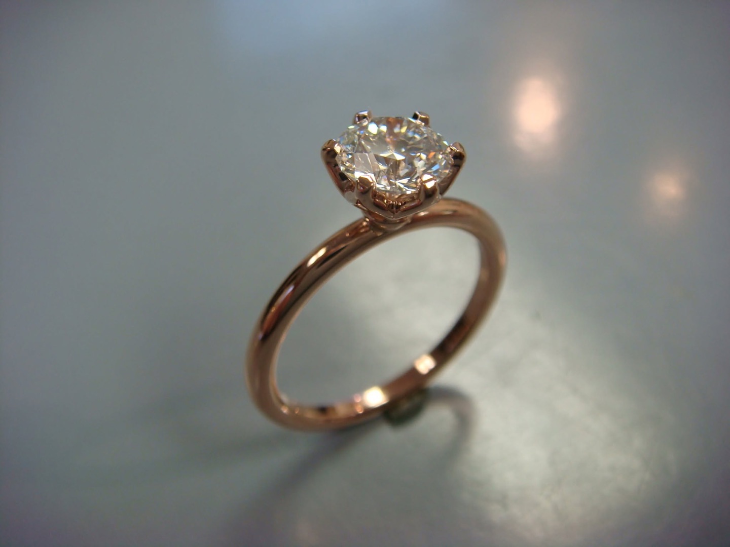 Gold solitaire engagement ring with a round diamond in a crown setting