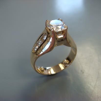 Gold diamond engagement ring with a sculpted, pavé-set shank