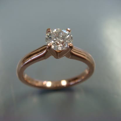 Gold diamond solitaire engagement ring with a cathedral setting