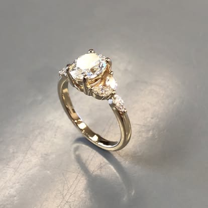 Gold engagement ring with a round diamond and floral side accents