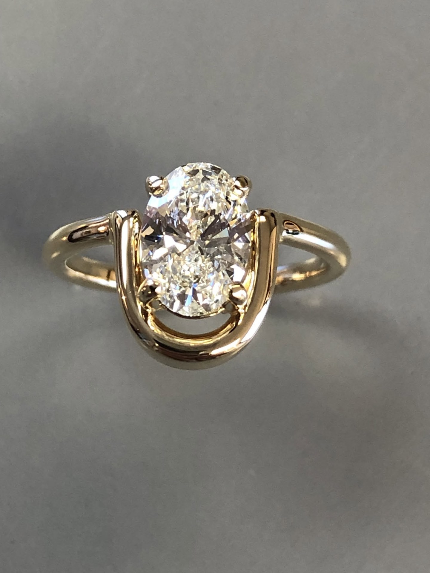 Gold ring with an oval diamond set in an open, sculpted mounting