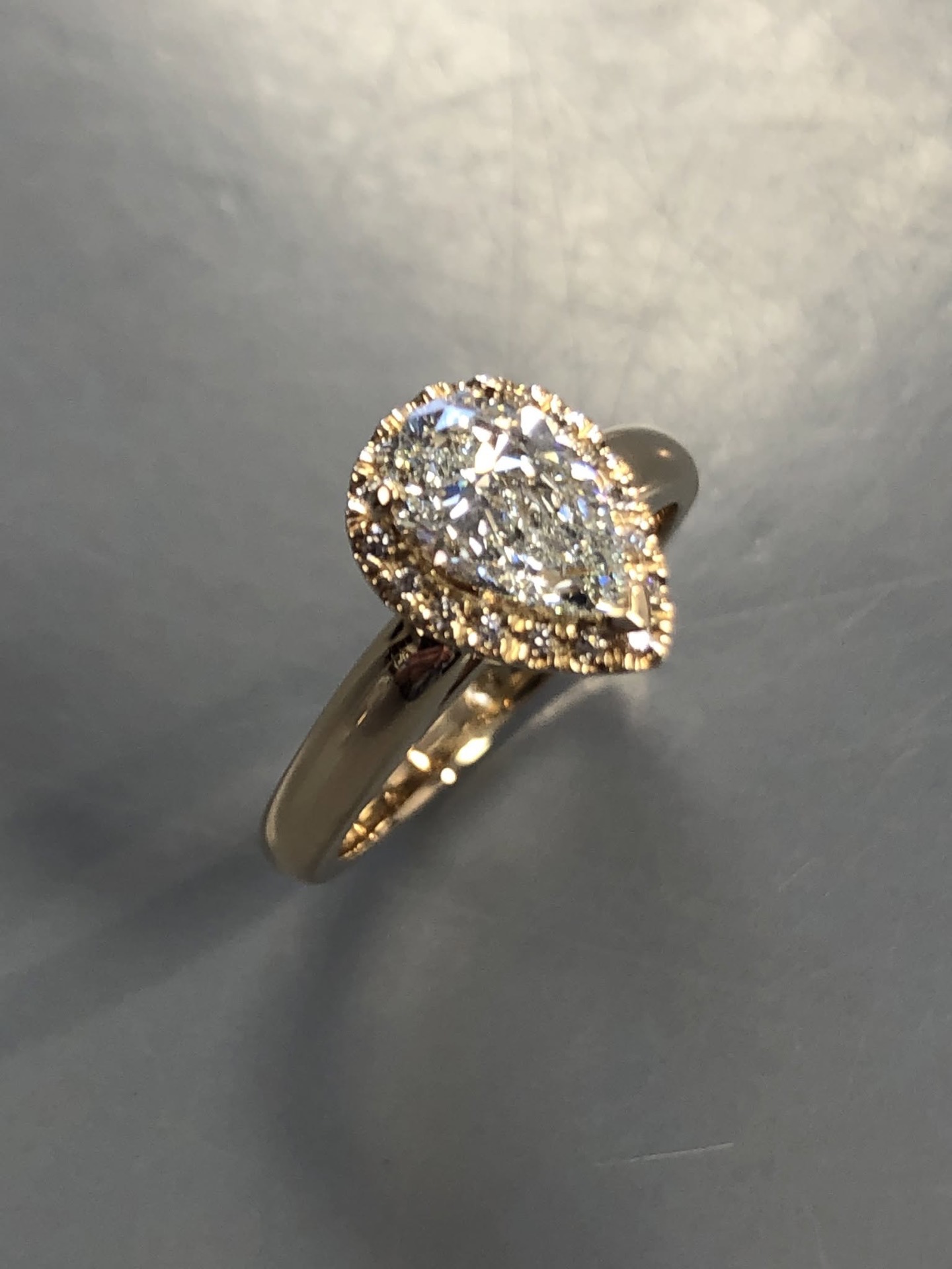Gold pear-shaped diamond halo engagement ring