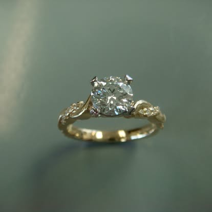 Gold round diamond engagement ring with diamond-set shoulders