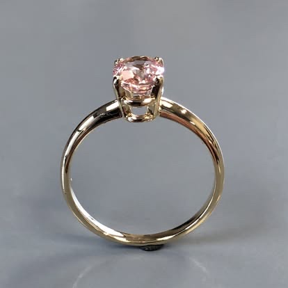Gold solitaire engagement ring with a pink gemstone