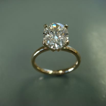 Oval diamond solitaire engagement ring in yellow gold