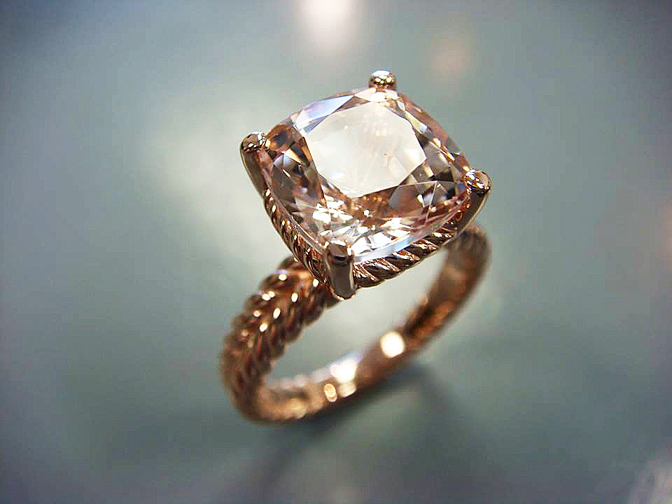 Cushion-cut peach gemstone engagement ring in gold with a hand-twisted rope band