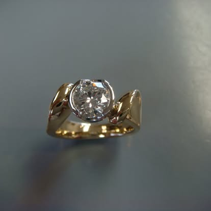 Two-tone gold ring with a bezel-set round diamond