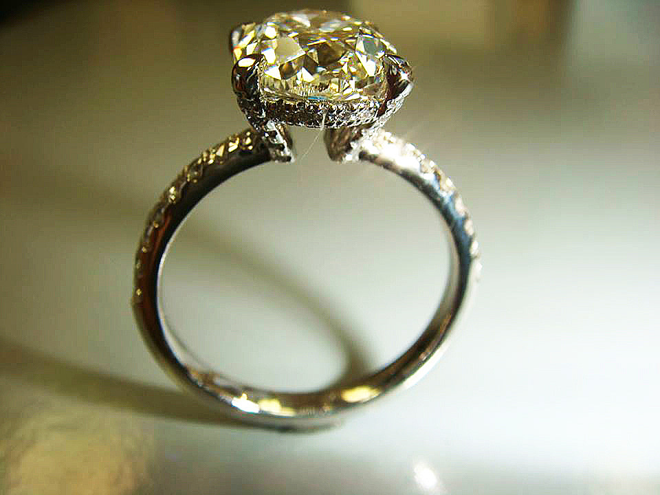 Tall white gold diamond solitaire with a vintage-style pavé basket