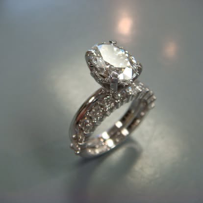 White gold oval diamond engagement ring with a pavé band