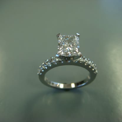 White gold princess-cut diamond engagement ring with a pavé band
