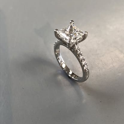 White gold princess-cut diamond solitaire with a pavé band