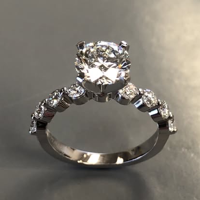 White gold round diamond ring with graduated side stones