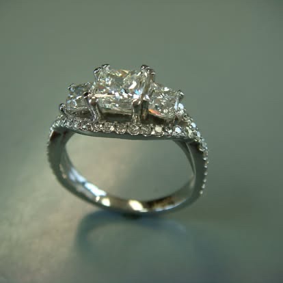 White gold three-stone engagement ring with pavé shoulders
