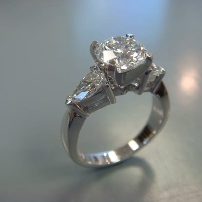White gold three-stone engagement ring with pear-shaped side diamonds