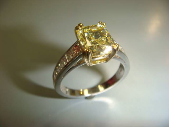 Yellow cushion-cut center stone with a channel-set princess diamond band