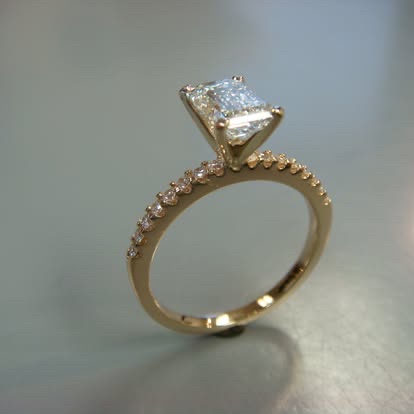 Yellow gold princess-cut diamond solitaire with a pavé band