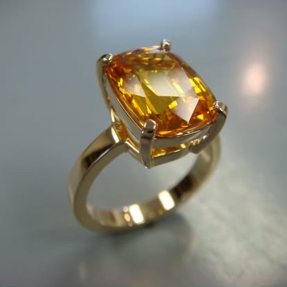 Cushion-cut golden gemstone ring in yellow gold