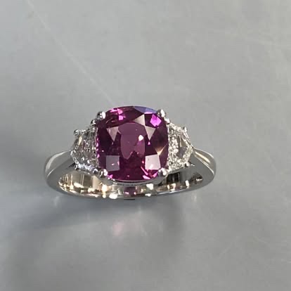 Cushion pink-purple gemstone ring with diamond sides in white gold