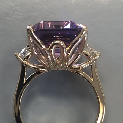 Emerald-cut purple gemstone ring in a sculpted gold setting