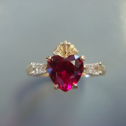 Heart-shaped ruby ring with diamond sides in gold
