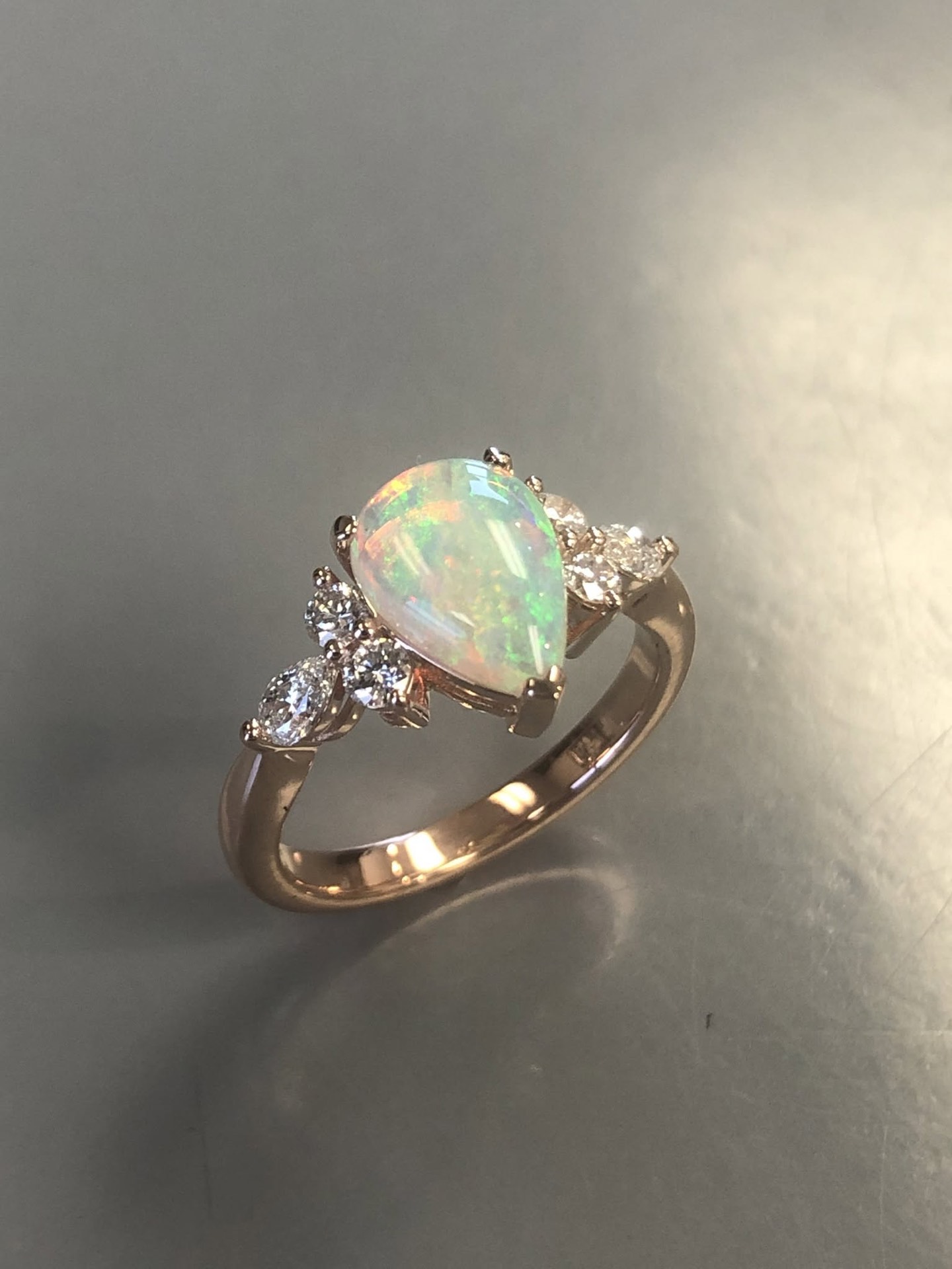 Pear-shaped opal ring with diamond accents in gold