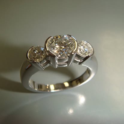 Three-stone ring with bezel-set yellow diamonds in white gold