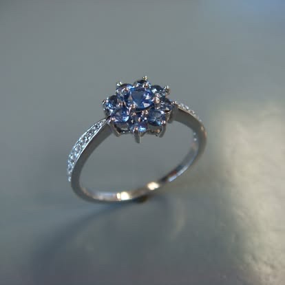 White gold ring with a blue sapphire cluster and pavé band