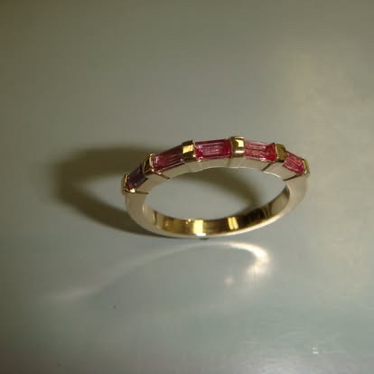 Yellow gold band with channel-set red gemstones