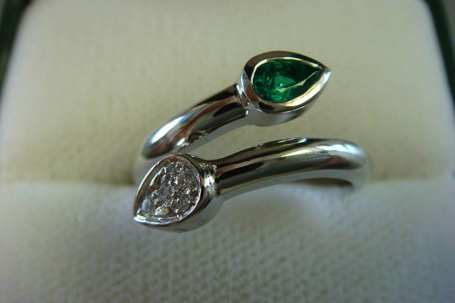 White gold bypass ring with a pear emerald and a pear diamond
