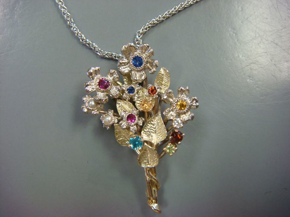 Gold flower bouquet pendant set with colored gemstones