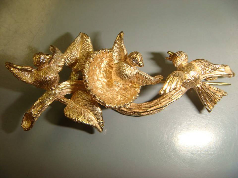 Hand-chased yellow gold brooch of birds around a nest