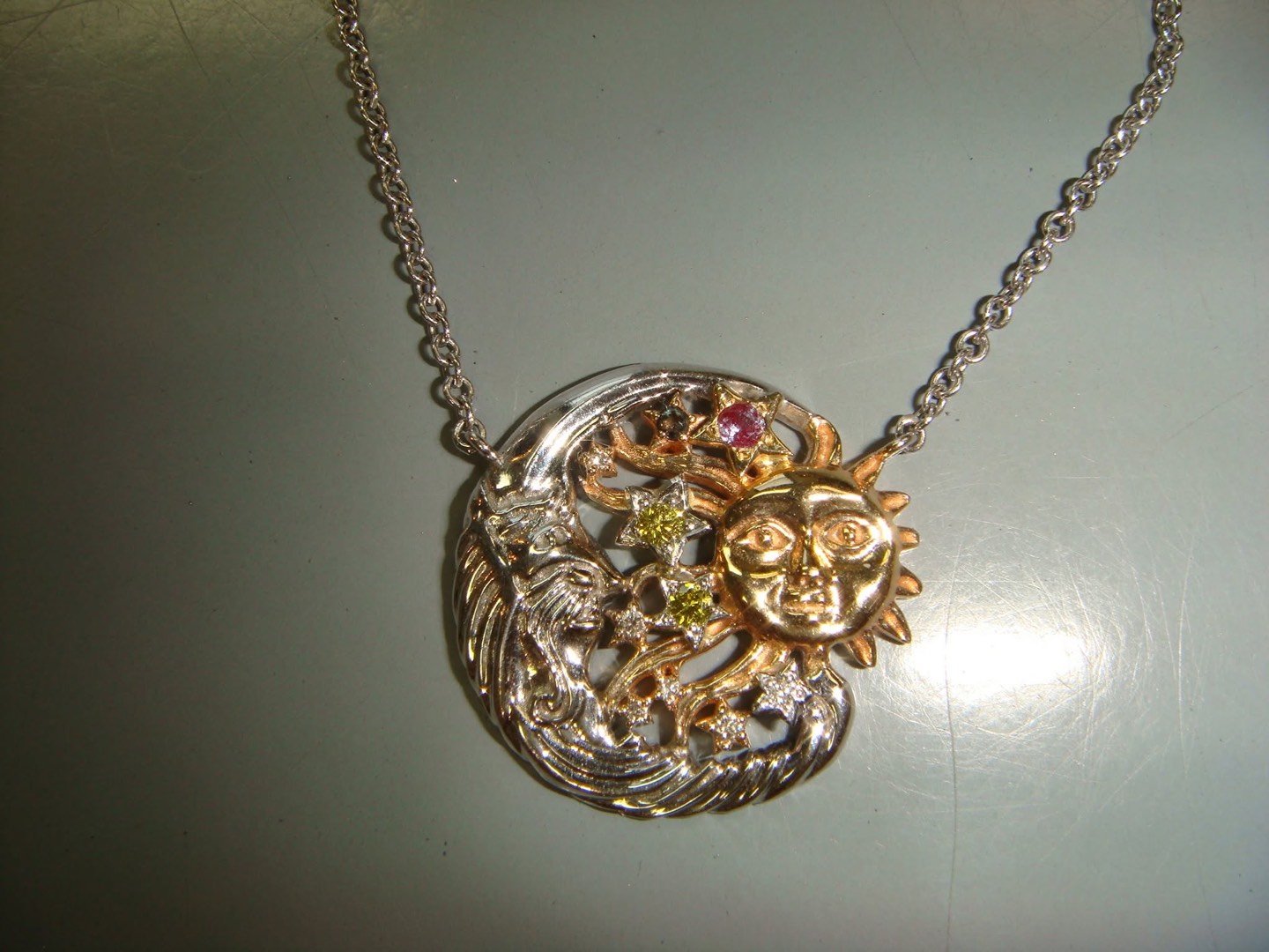 Handmade sun and moon pendant in gold and white gold with colored gemstones