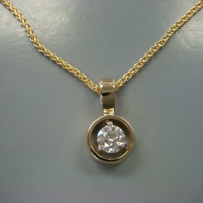 Bezel-set round diamond pendant in yellow gold