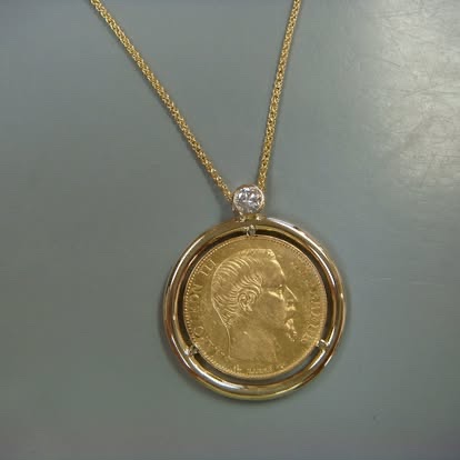 Gold coin pendant in a yellow gold bezel frame