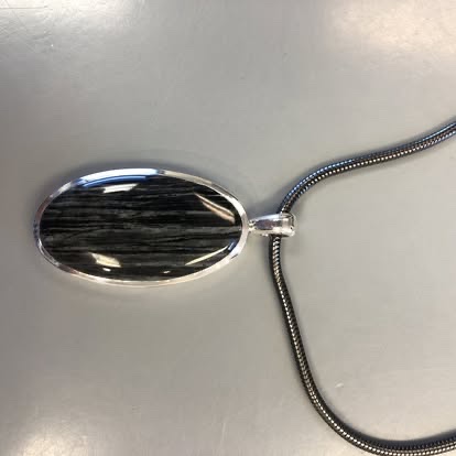 Oval black-and-white stone pendant on a white gold chain