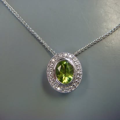 Oval green gemstone pendant with a diamond halo in white gold