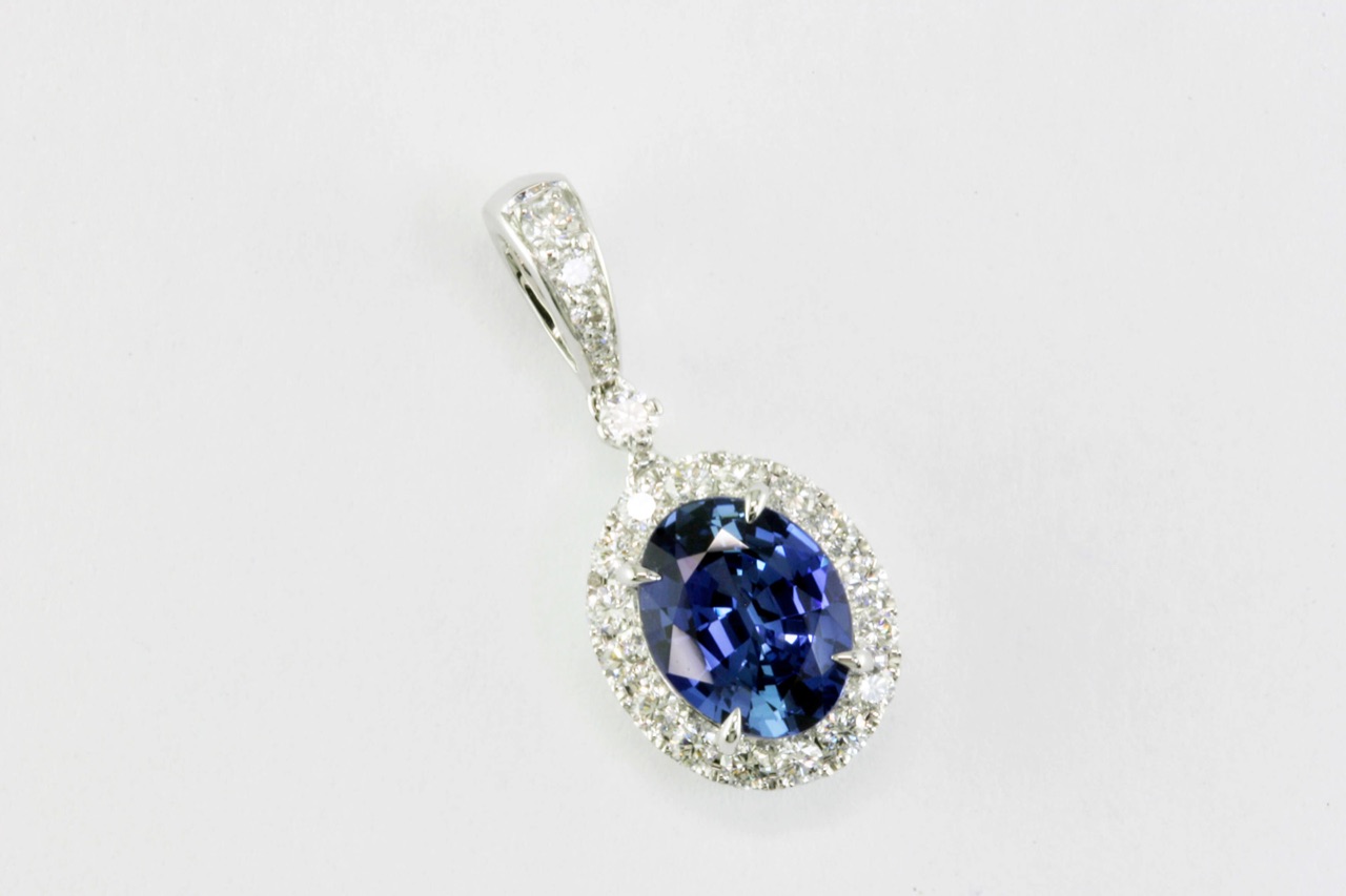 Oval blue sapphire pendant with a diamond halo