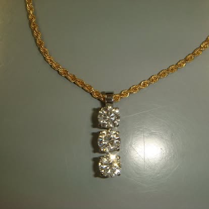 Three-stone diamond drop pendant on a yellow gold chain