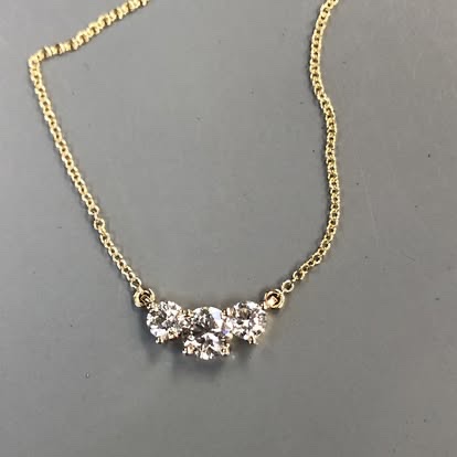 Three-stone diamond necklace on a yellow gold chain