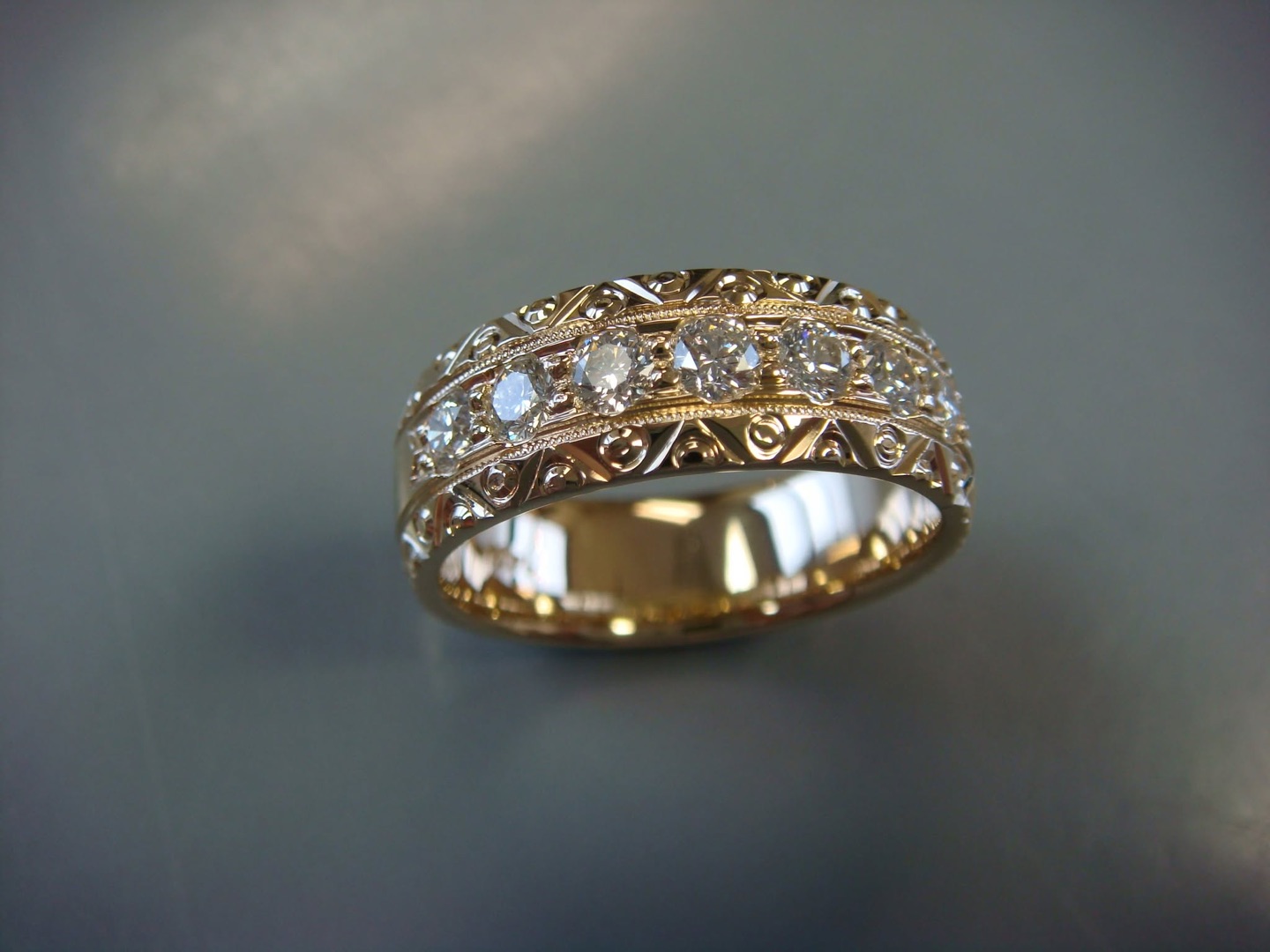 Gold filigree band with a row of diamonds and milgrain edges