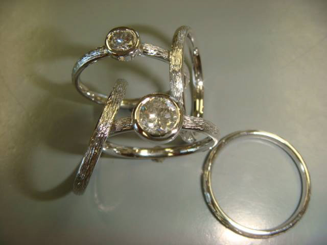 Hand-engraved white gold stacking rings with bezel-set diamonds