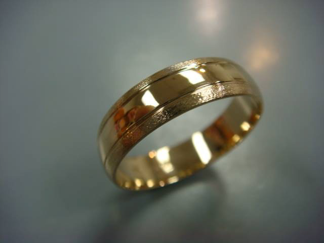 Men's two-tone wedding band with a textured yellow gold center